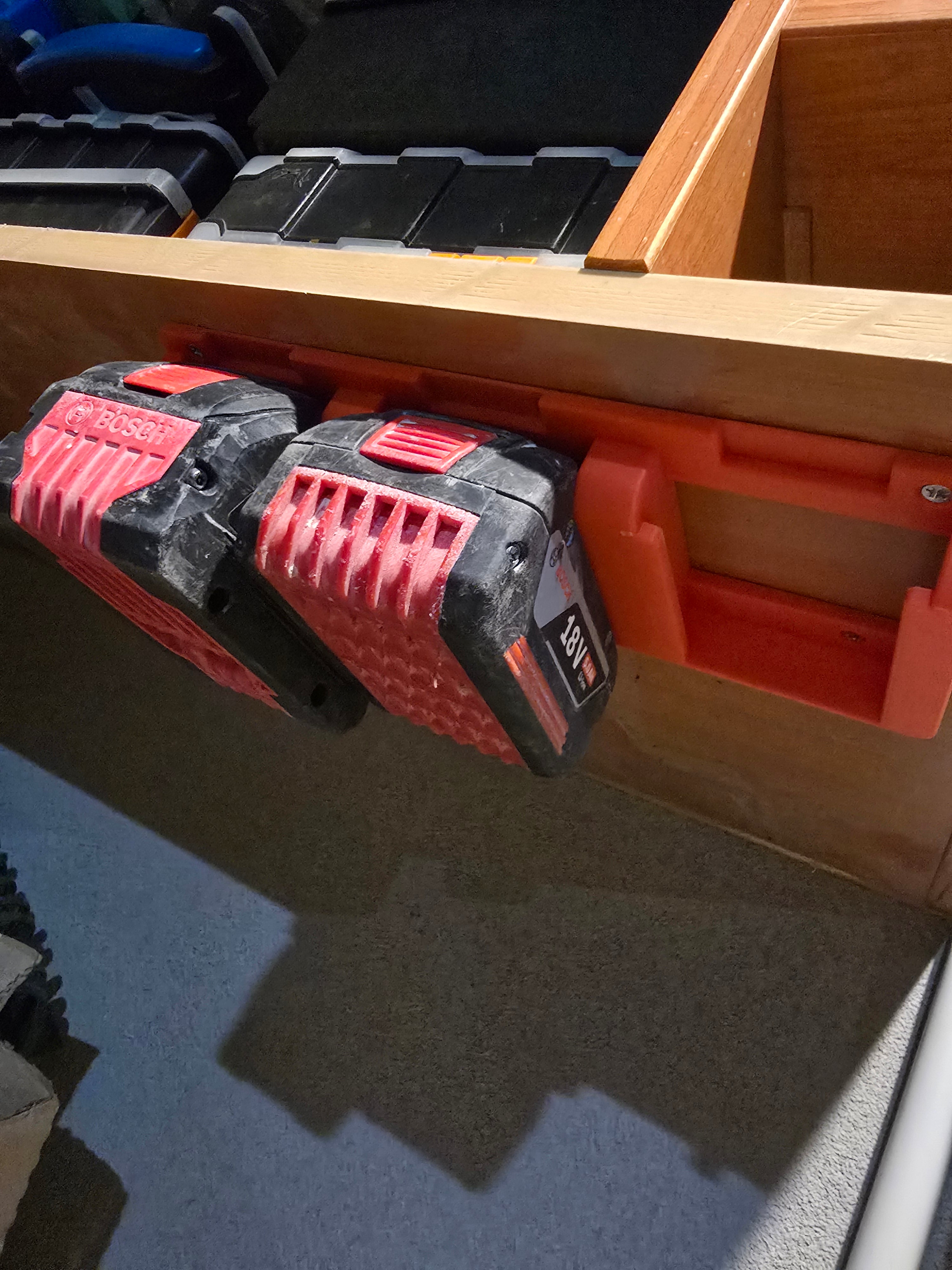 3D printed battery holder mounted under workbench holding two Bosch 18V batteries