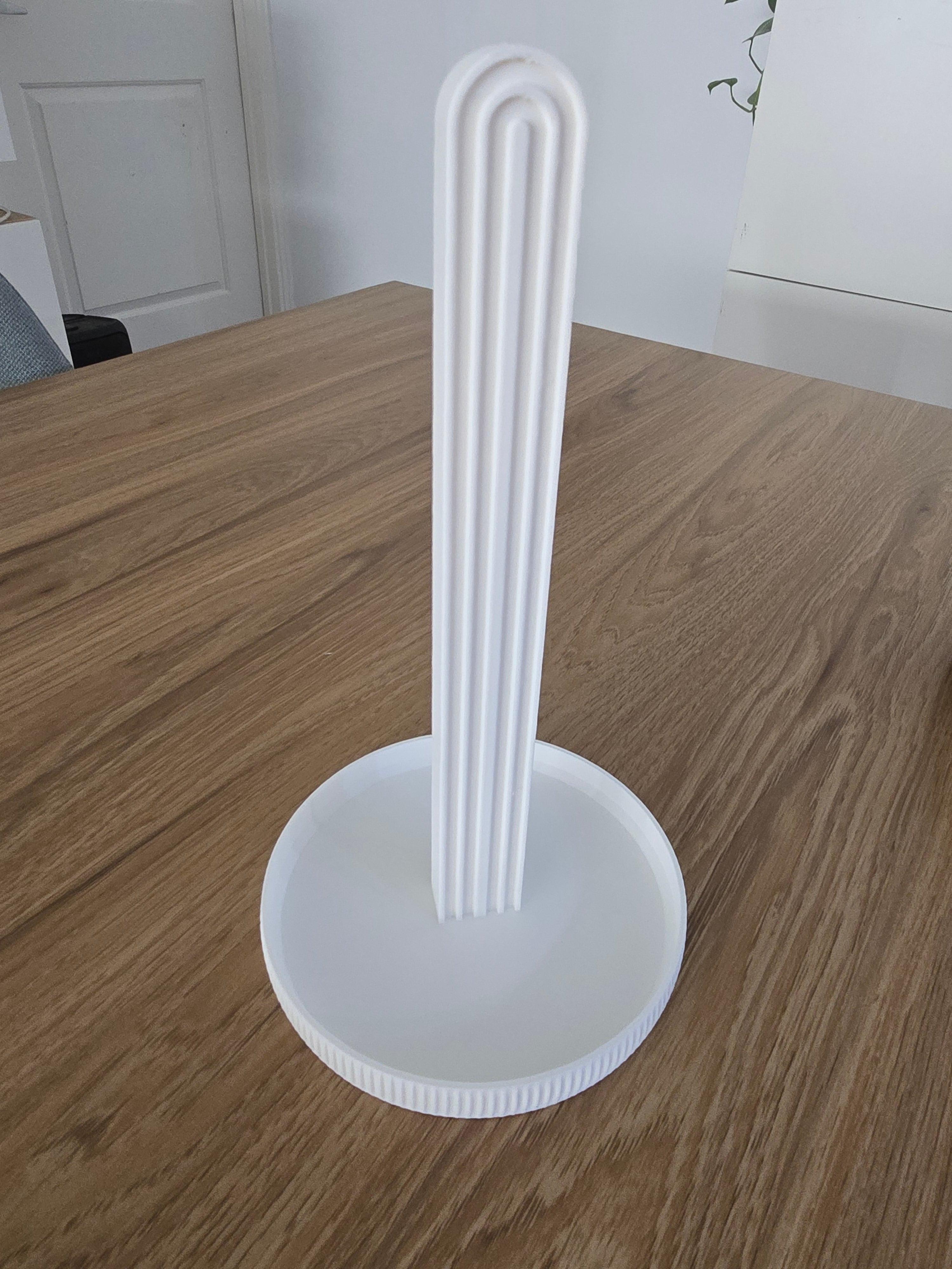 3D printed white ribbed arch hair tie stand on wooden table